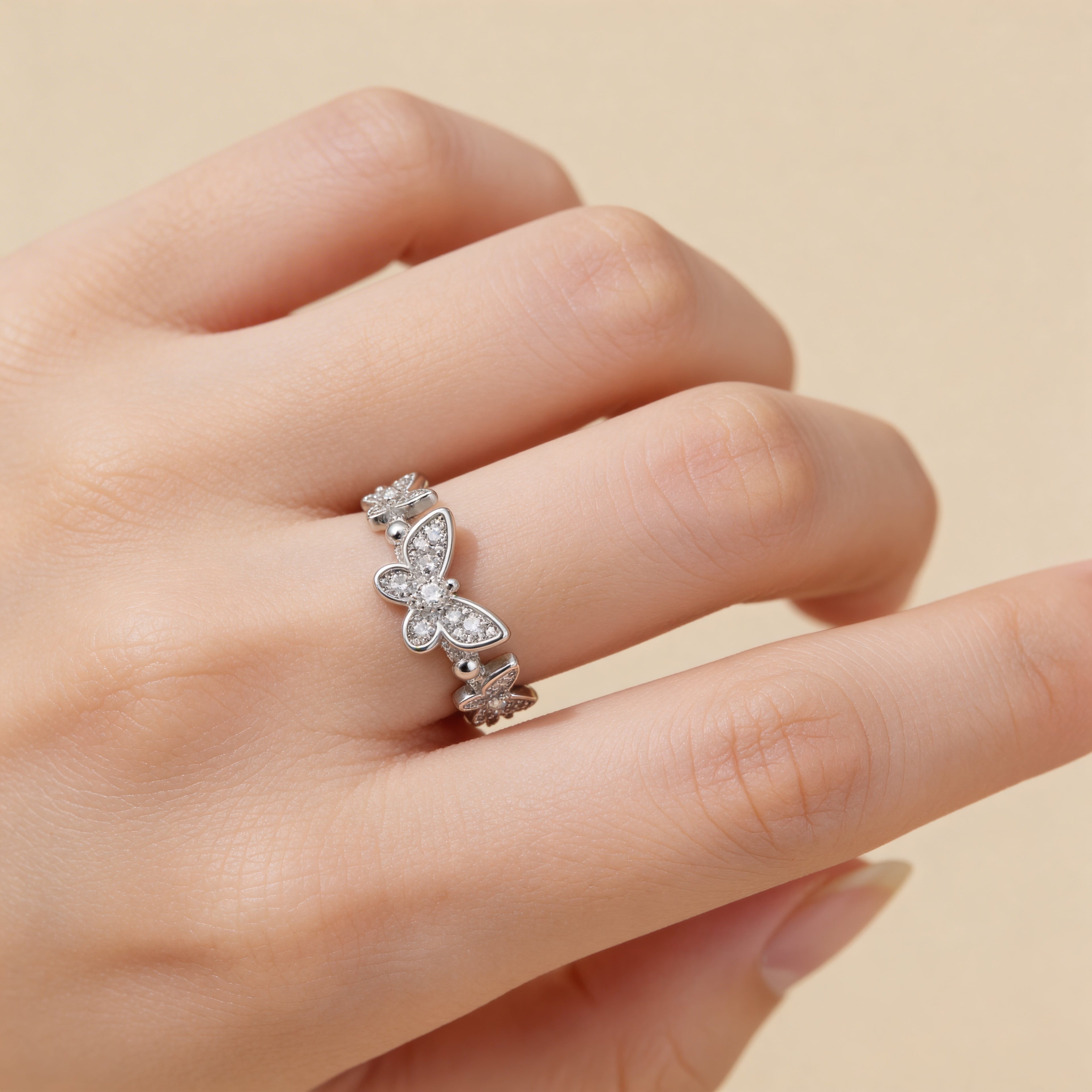 Adjustable silver butterfly ring worn on hand, dainty CZ statement jewelry.