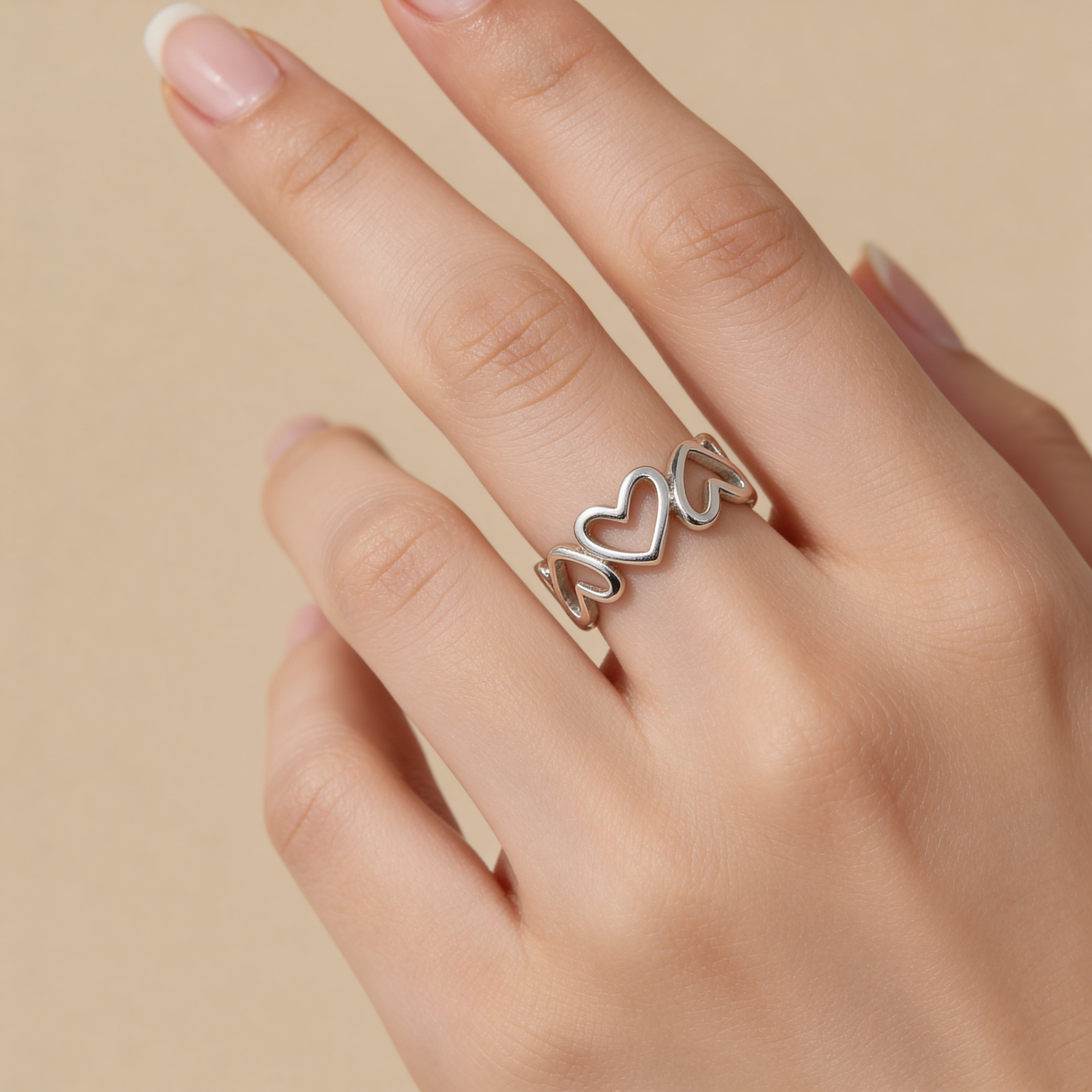 Adjustable silver open heart band ring worn on hand, minimalist romantic jewelry.