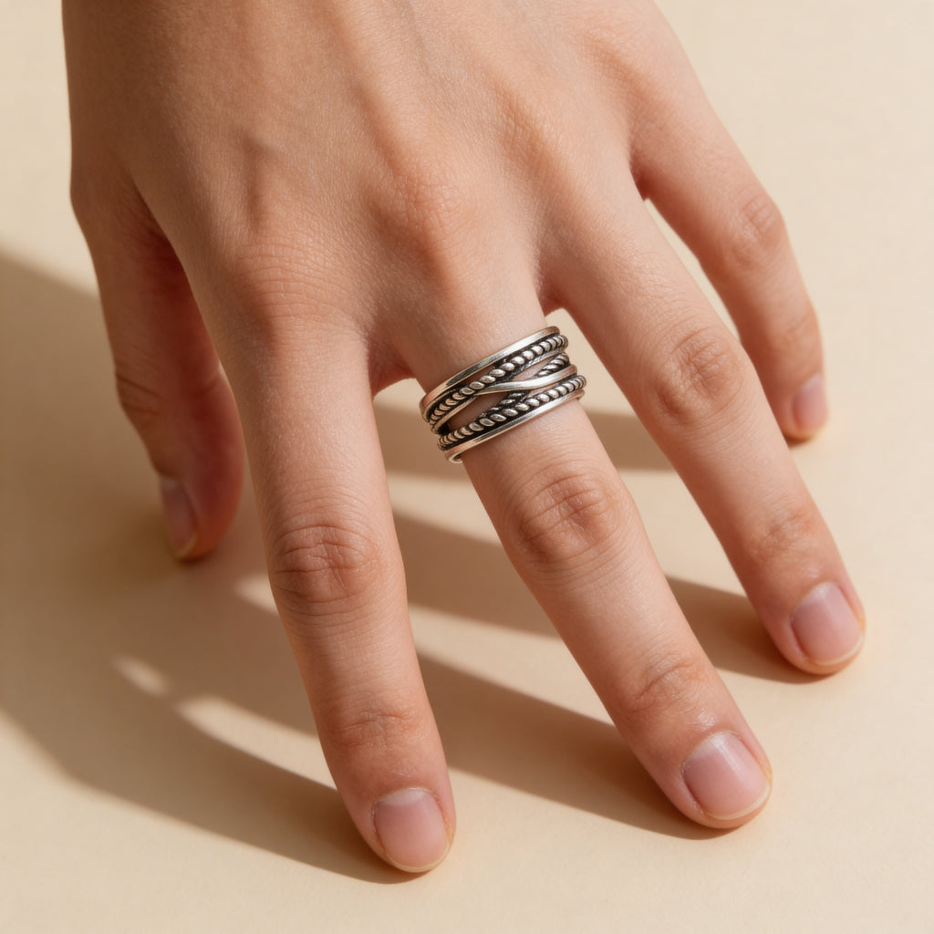 Silver braided rope adjustable ring with layered twisted band design.