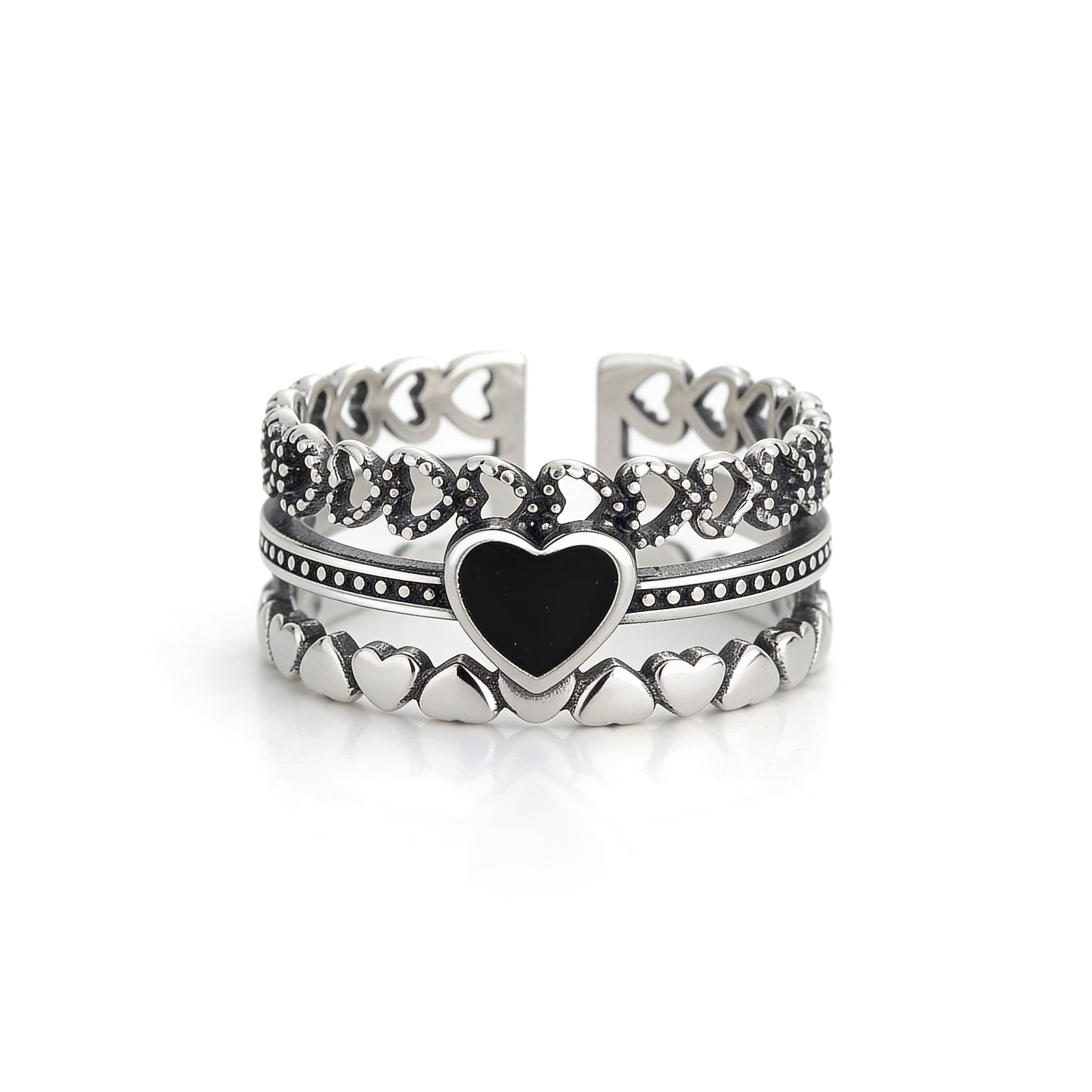 Black heart silver ring worn on hand with stacked layered design and textured detailing