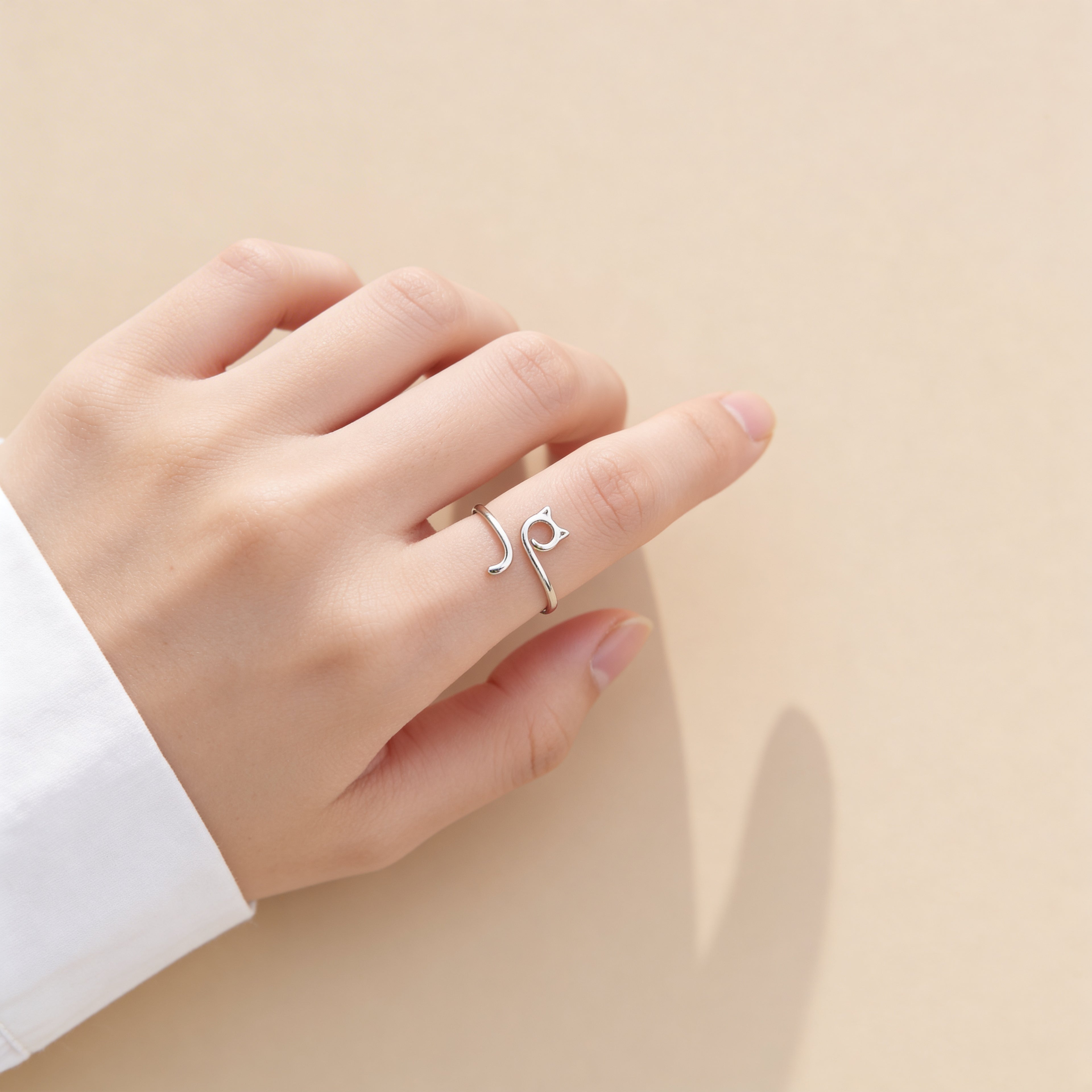 Dainty silver cat shaped adjustable ring styled on hand.