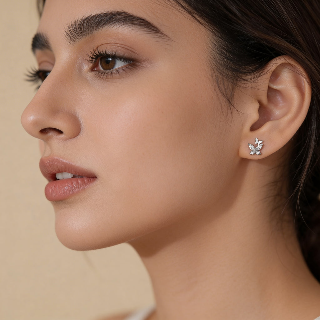 Minimal silver butterfly stud earrings with crystals worn on ear subtle everyday jewellery