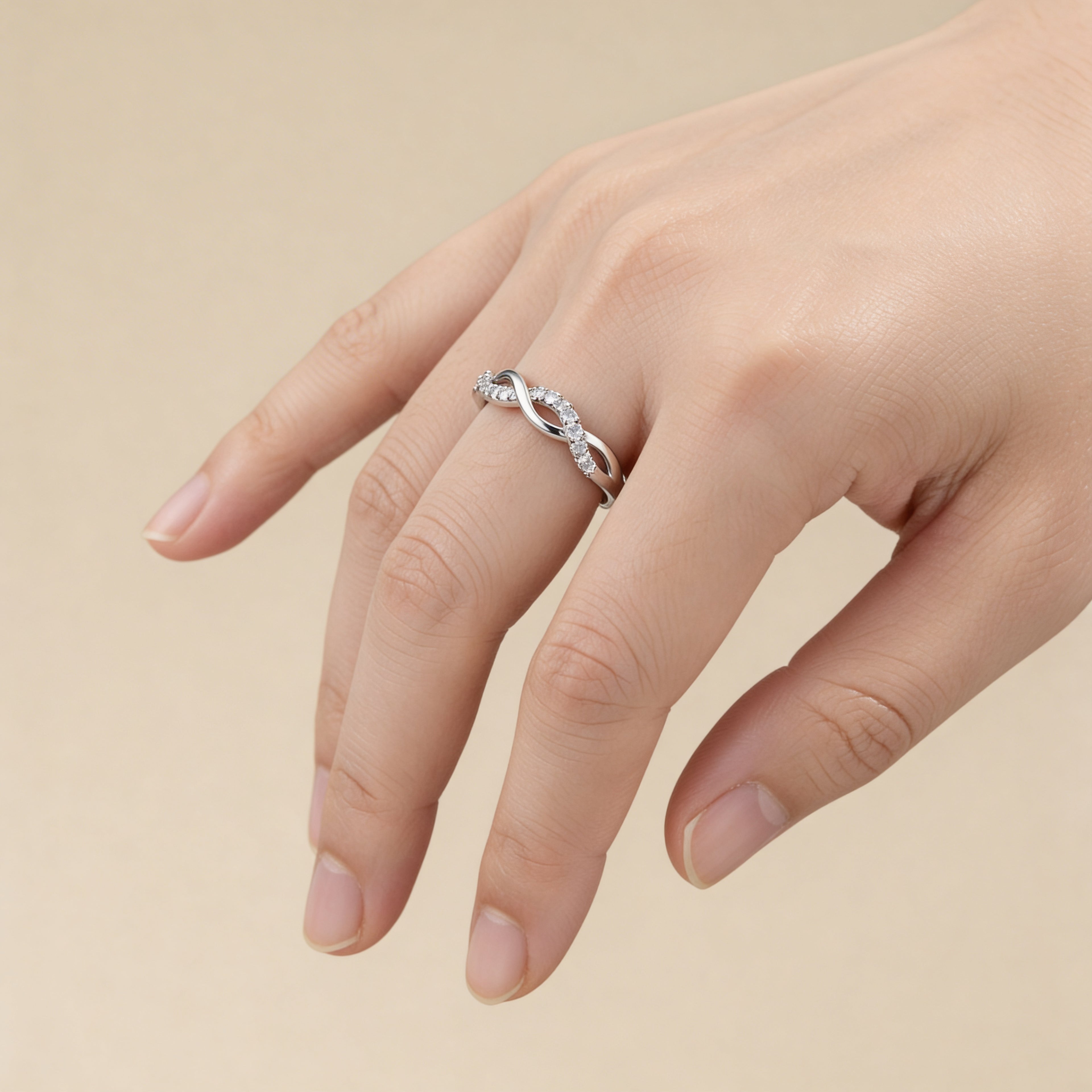 Cubic zirconia infinity ring in polished silver plated finish.