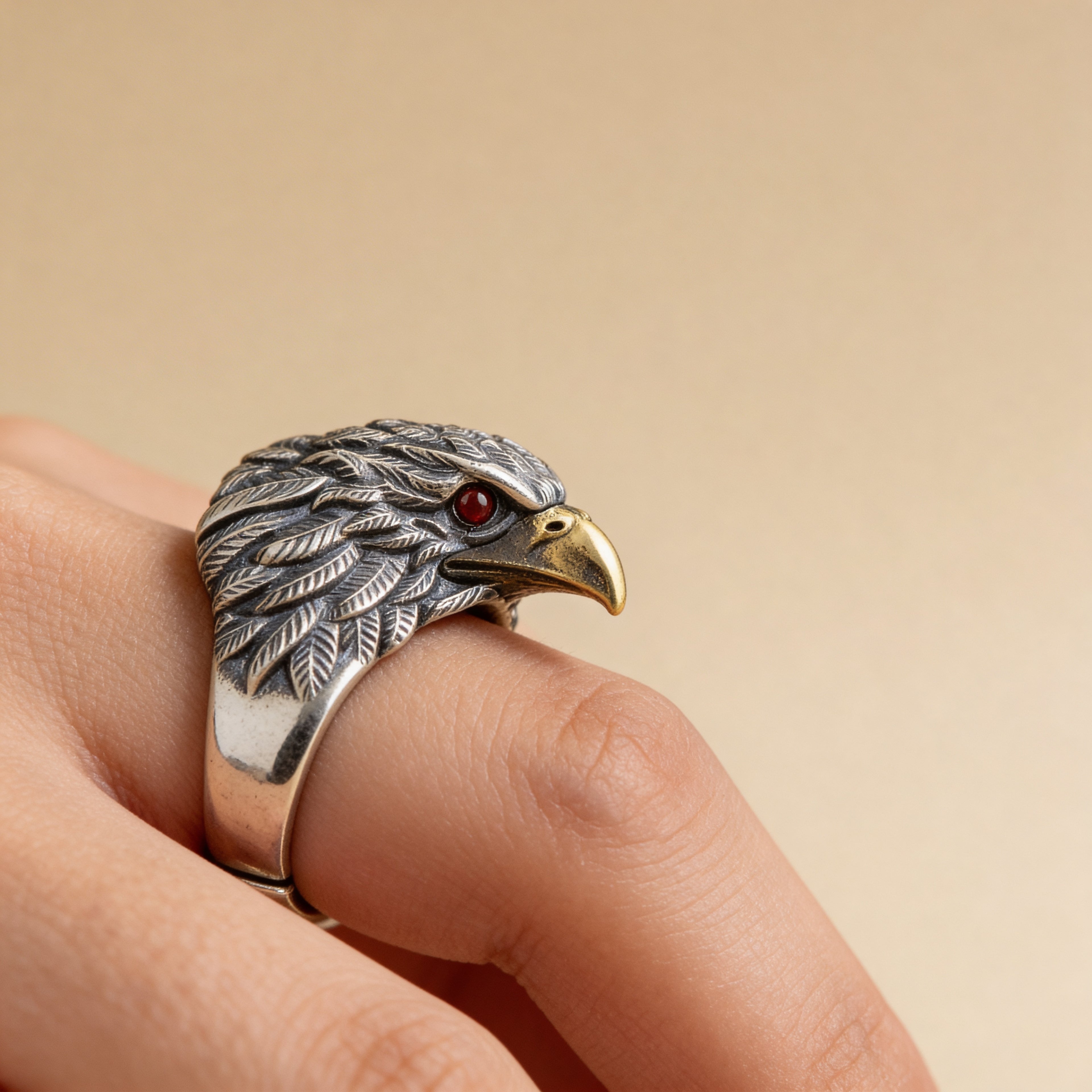 Bold silver eagle ring worn on finger with textured feather detailing.