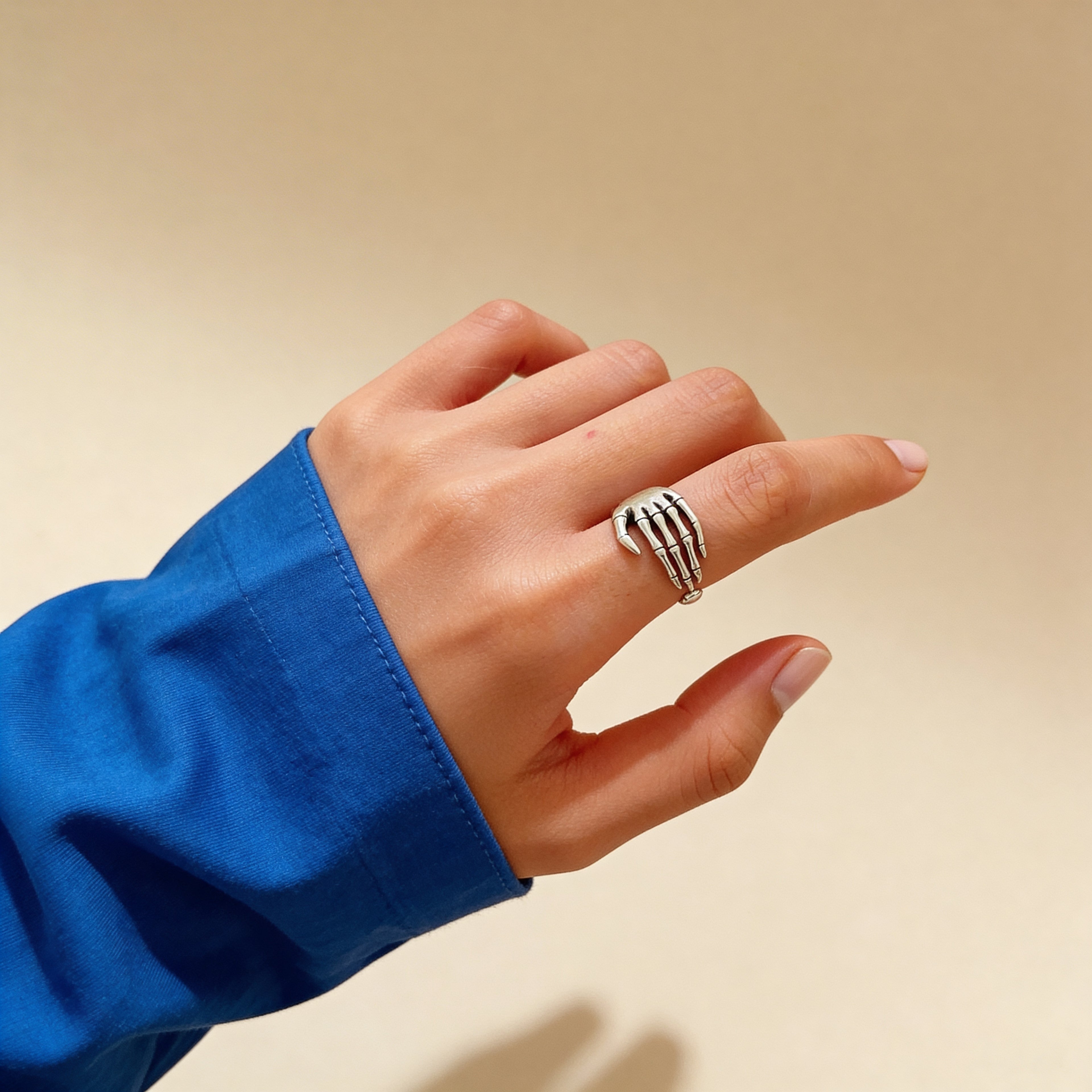 Skeleton hand ring worn on finger.
