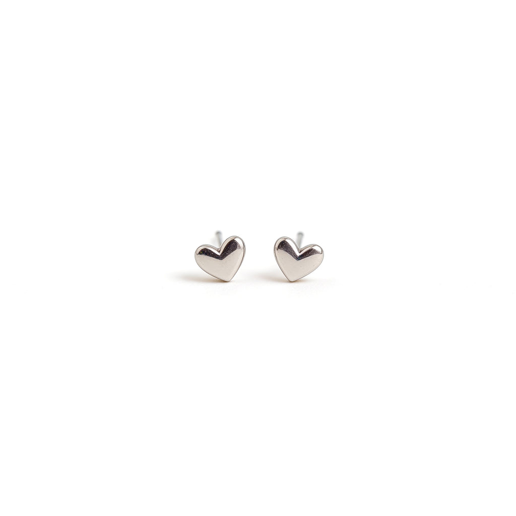 Mini silver plated heart stud earrings with polished finish on a white background