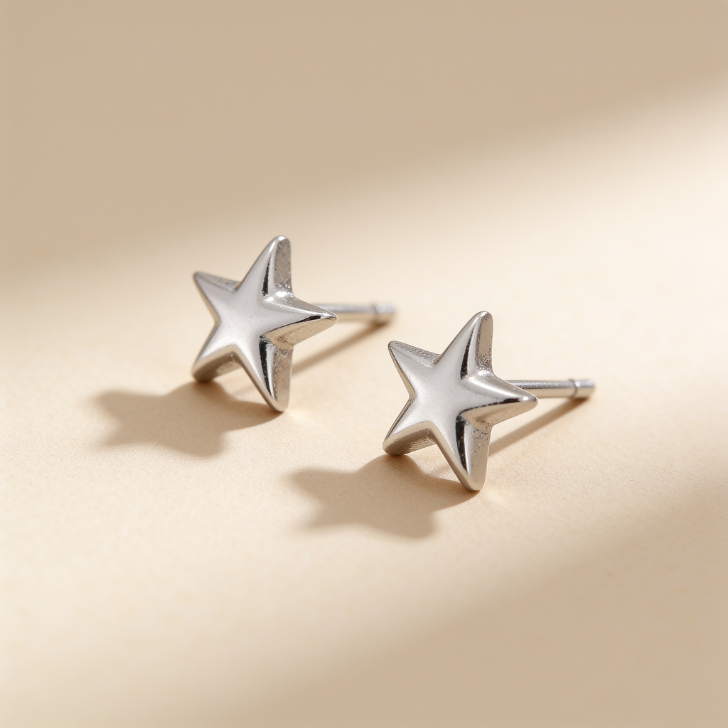 Mini silver plated star stud earrings on a soft beige background