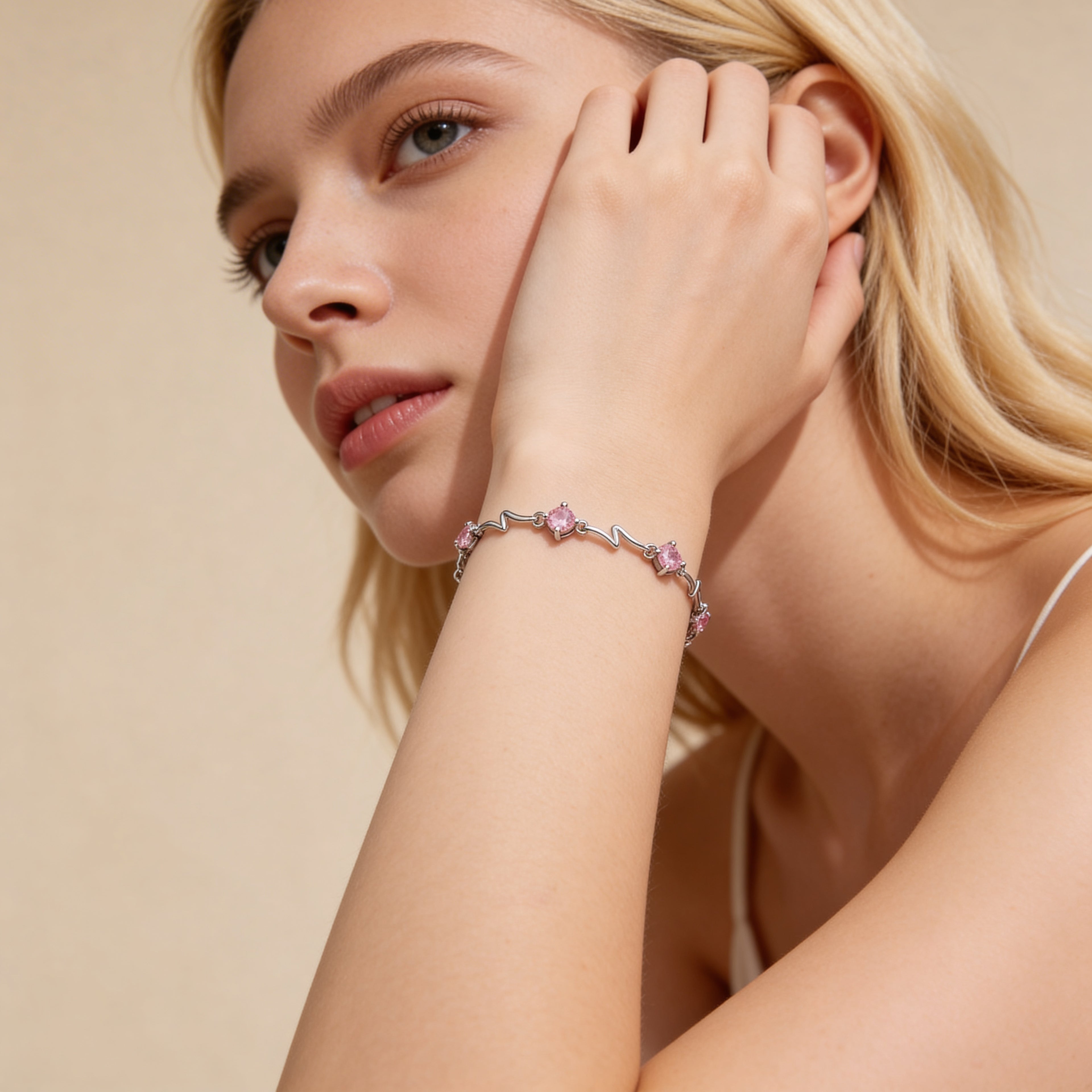 Silver plated pink crystal bracelet worn on wrist.