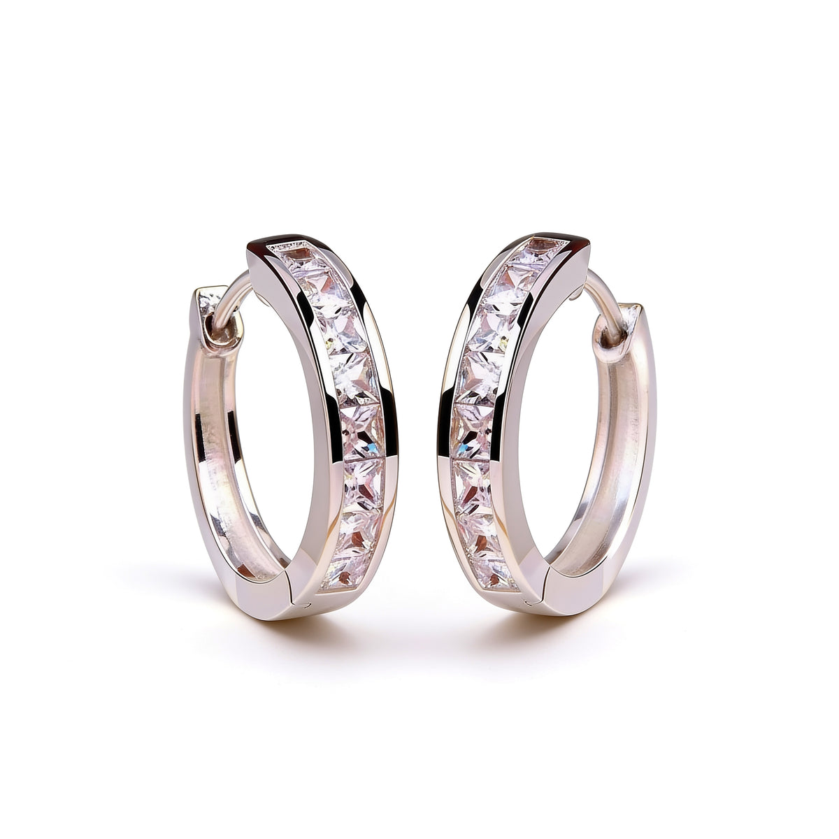 Silver plated crystal huggie hoop earrings with sparkling stones shown upright on a clean white background
