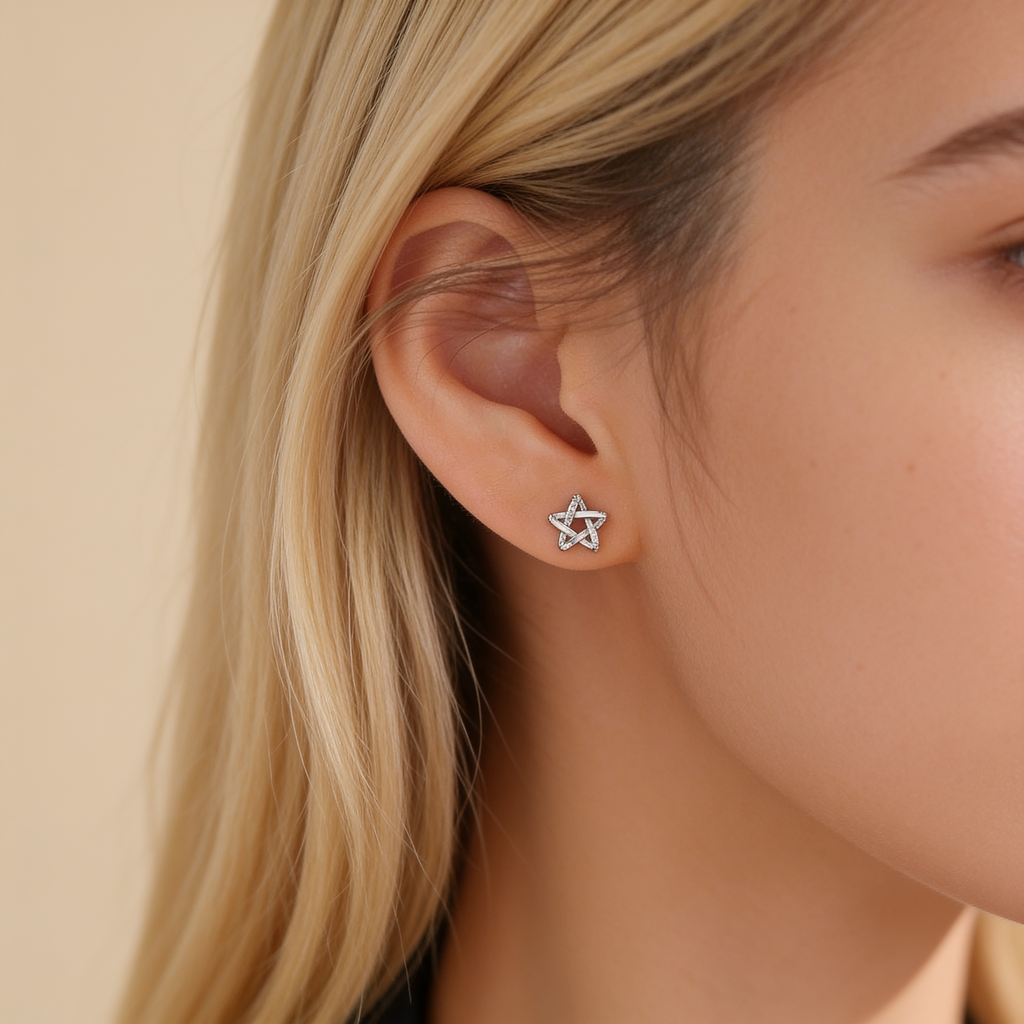 Silver plated star stud earring with sparkling crystal accents worn on the ear